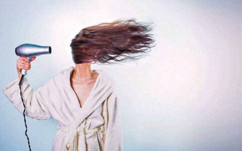 woman blow drying her hair