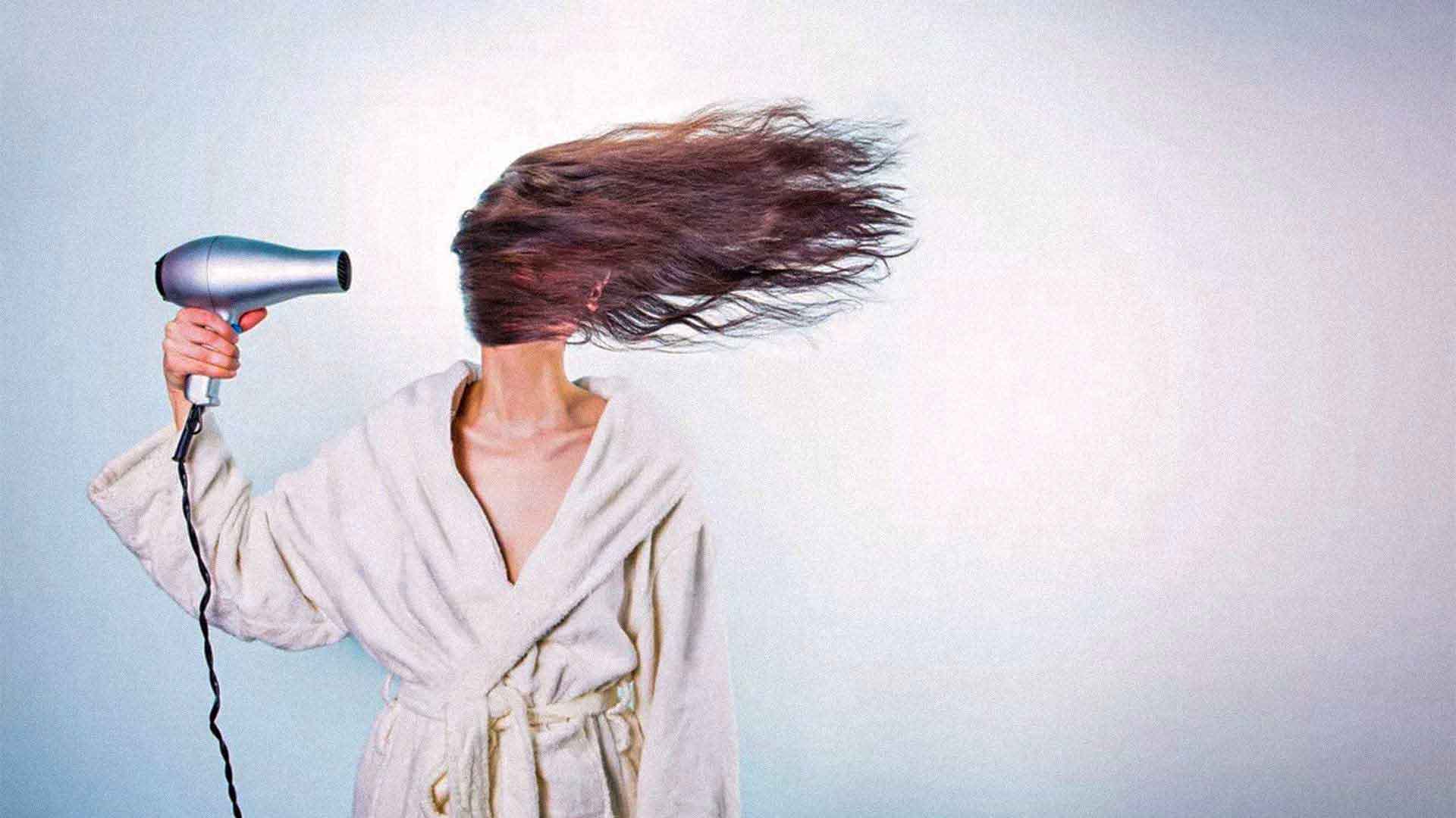 woman blow drying her hair