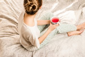 woman sitting on bed with tea