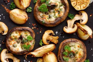 Mushrooms both stuffed and sliced laid out in a spread.