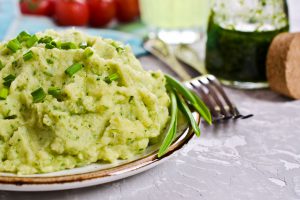 Creamy green mashed potatoes prepared on plate.