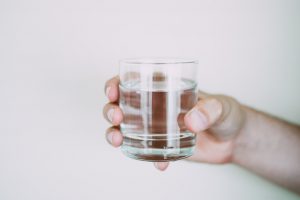 Person holding a glass of water