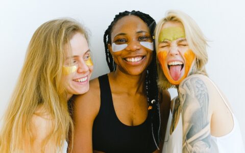 Three women with skincare products on face