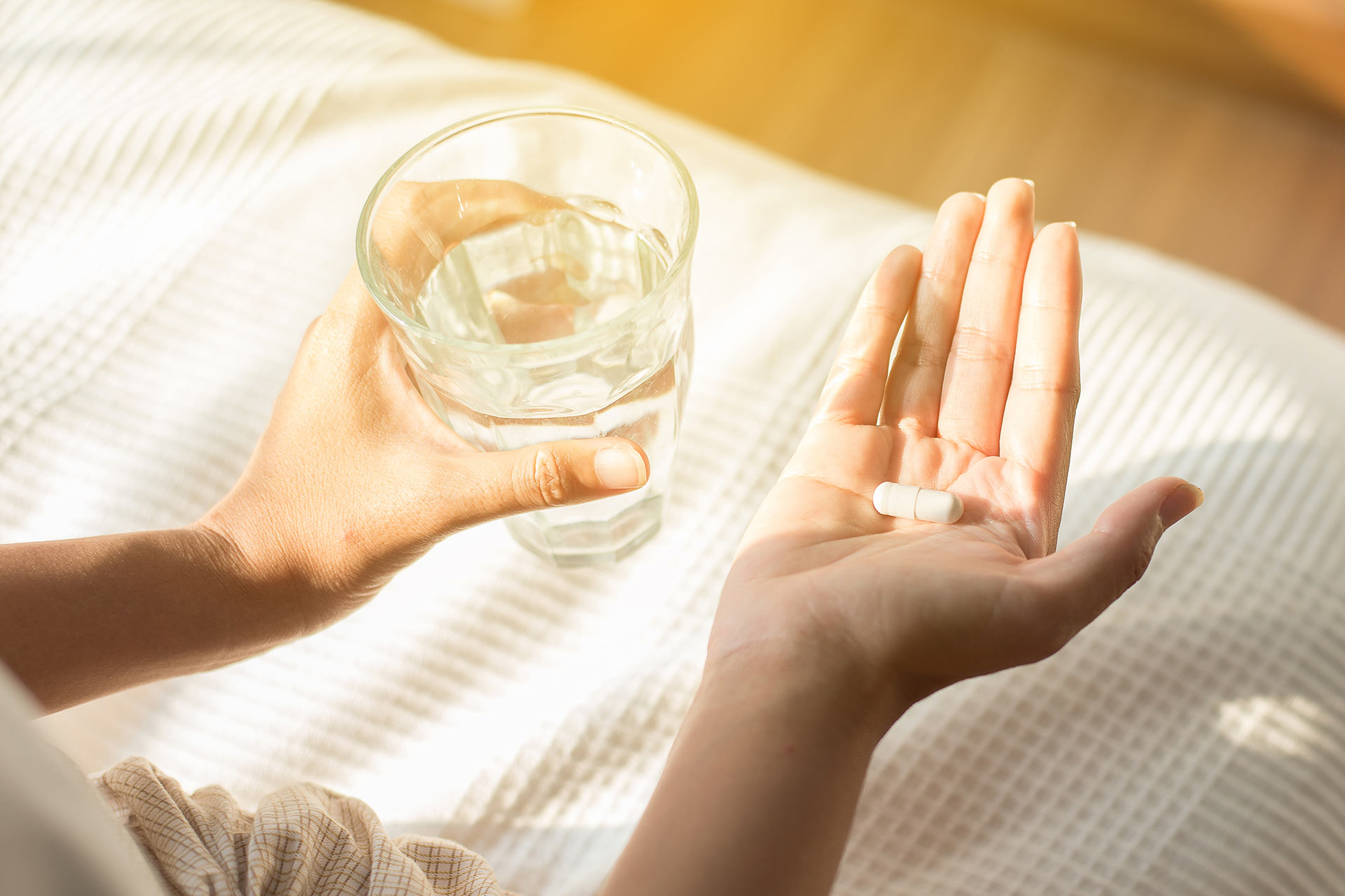 Glass of water with supplement in hand