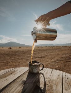 Coffee being poured into mug outside
