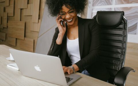 Woman on the phone sitting in front of her computer