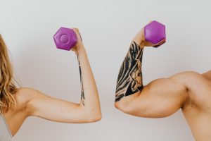 two people flexing holding dumbells
