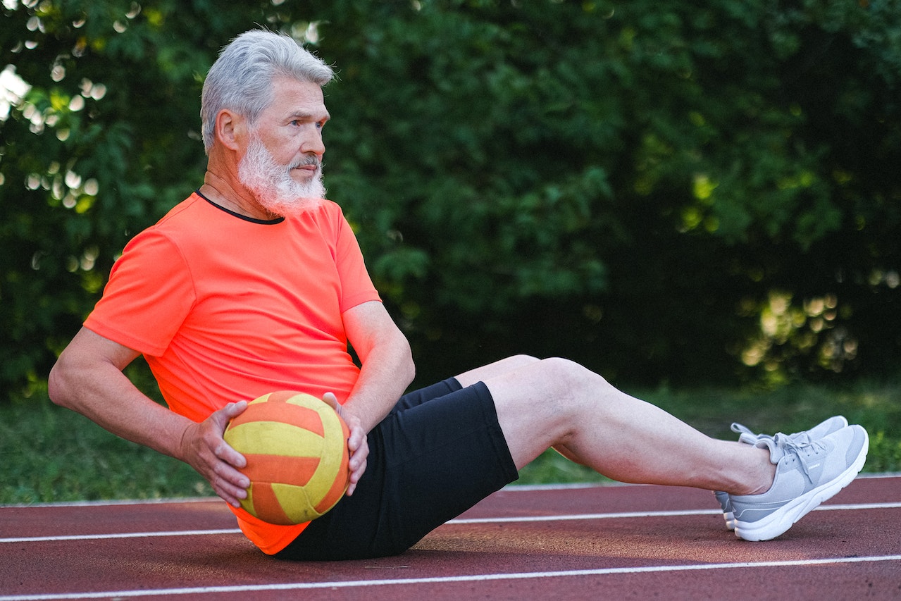 An older man exercising outside