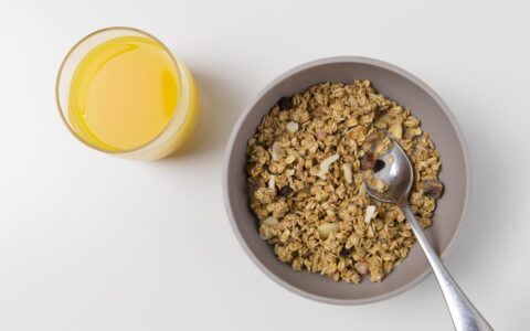 bowl of oats and cup of orange juice on table