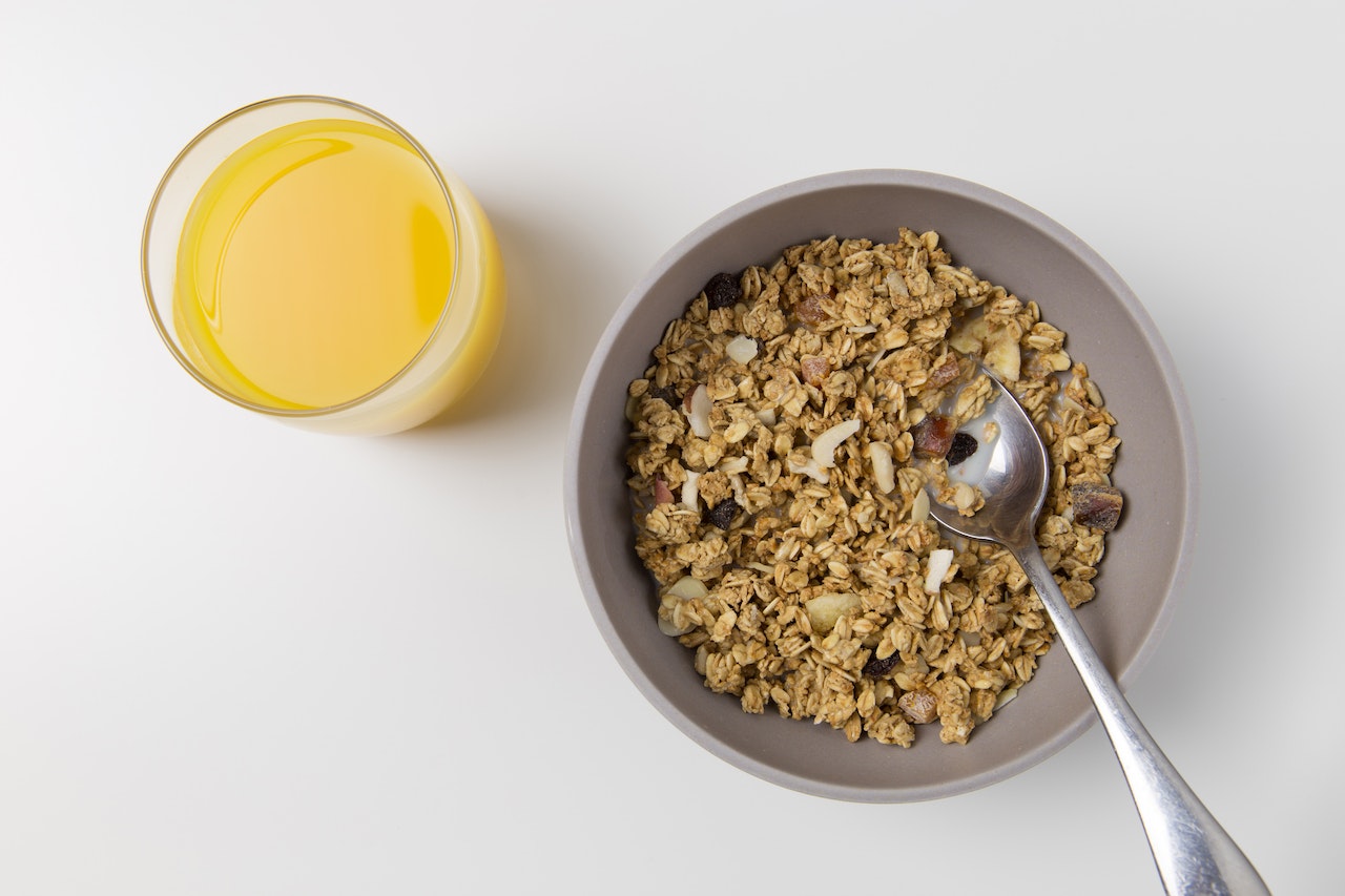 bowl of oats and cup of orange juice on table