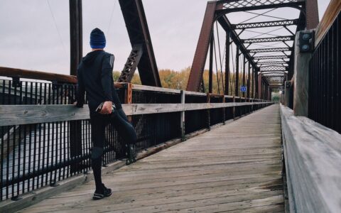 Man stretching on bridge