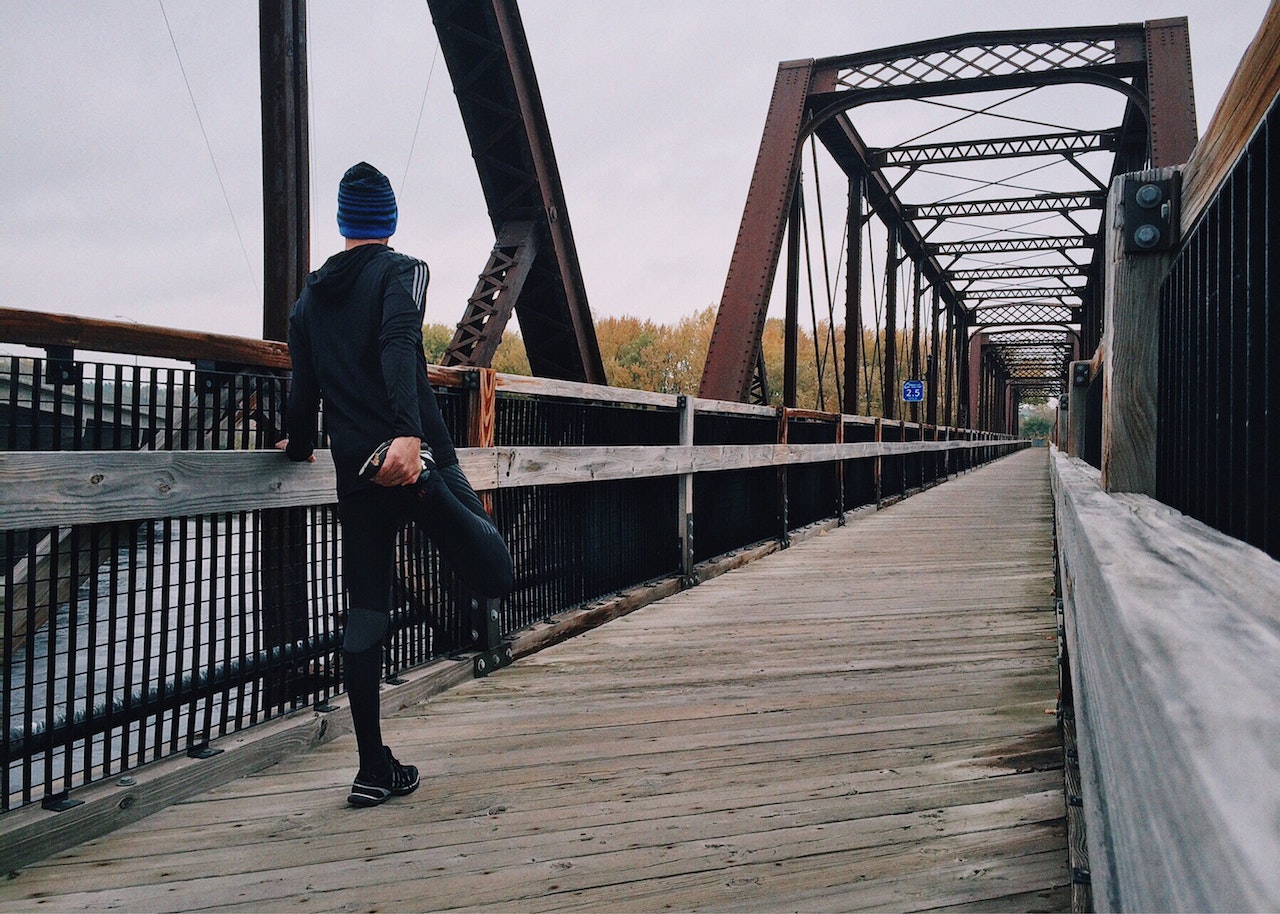 Man stretching on bridge