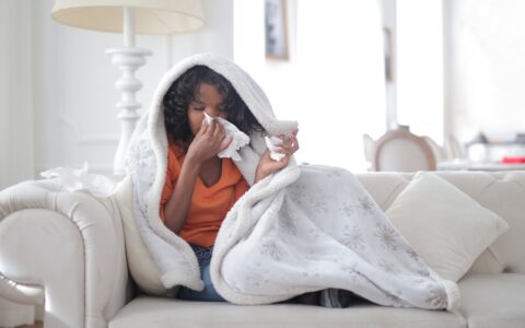 woman sitting on couch feeling ill