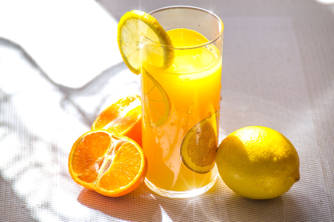 glass of orange juice with a slice of lemon