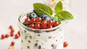 a jar of yogurt with fruit and mint