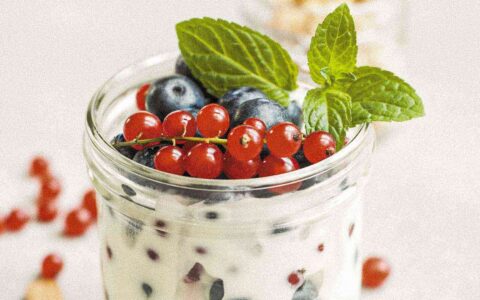 a jar of yogurt with fruit and mint