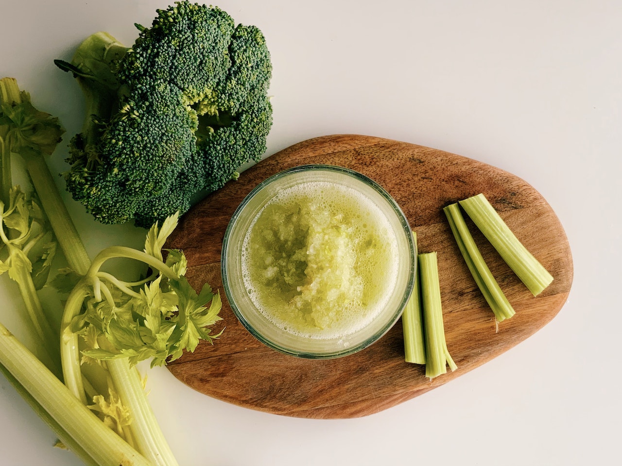 celery and broccoli on a wooden cutting board