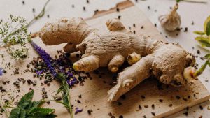 ginger root with herbs on a wooden cutting board