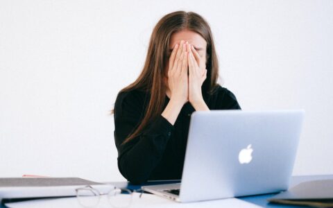 woman appearing stressed in front of computer