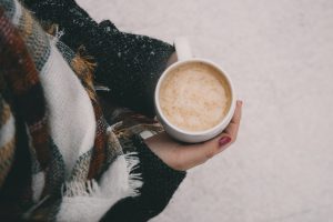 persona holding a mug outside during winter