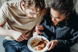 two people eating pancakes