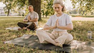 two seniors meditating outside