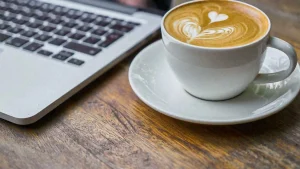 coffee next to a laptop