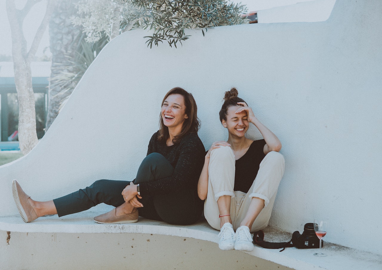 two women sitting and laughing with energy