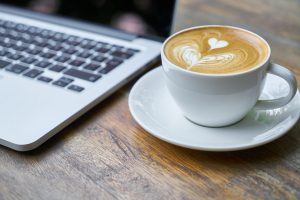 cup of coffee next to a keyboard