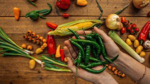 someone holding green chili peppers