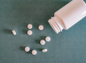 white pills next to a white bottle