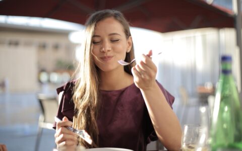 Woman eating her meal with a smile