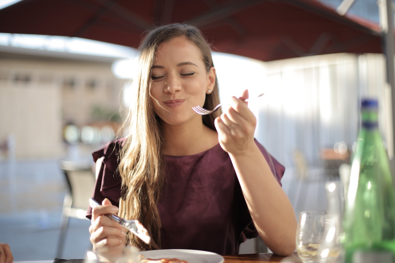 Woman eating her meal with a smile
