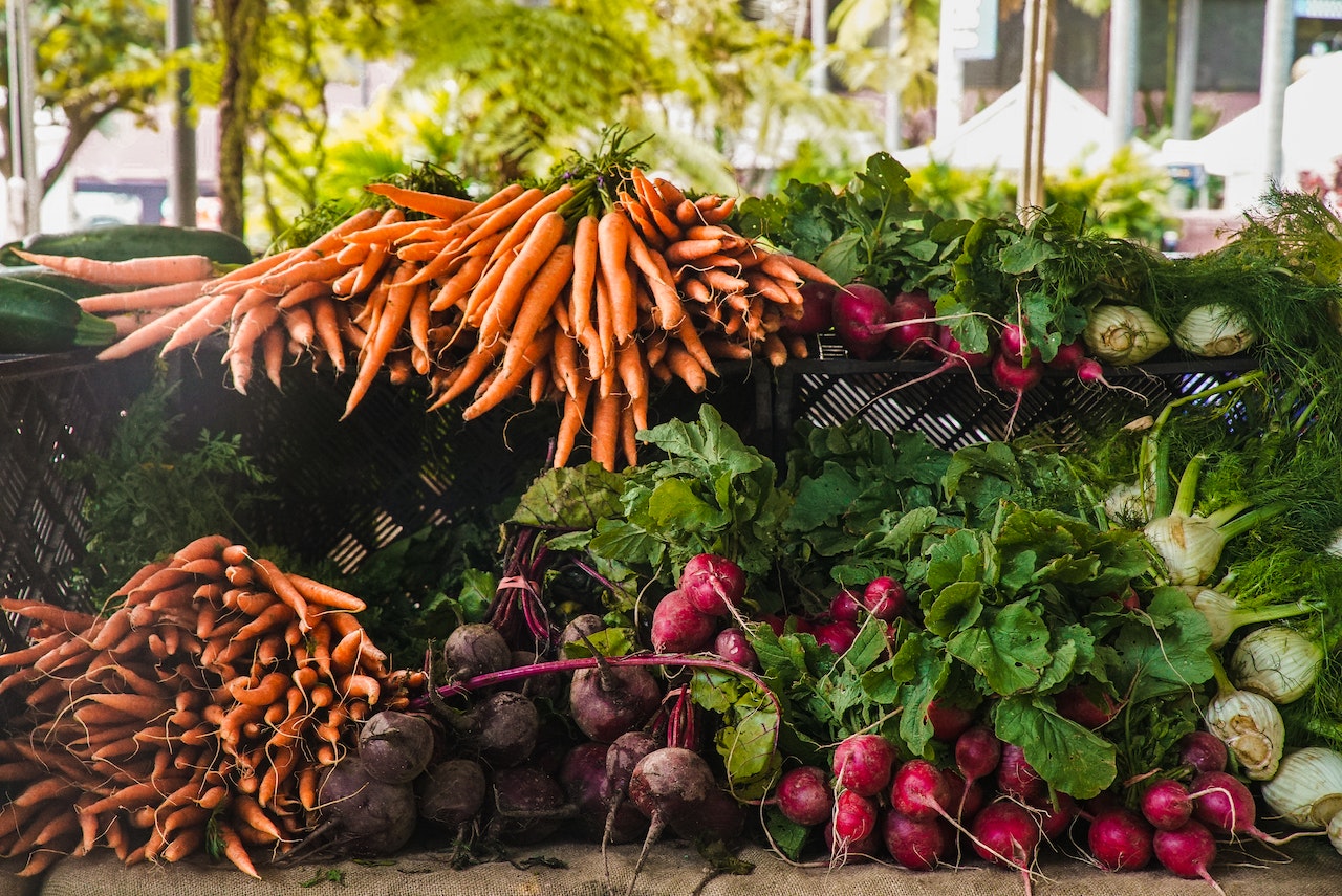 market with different vegetables like carrots, beets and radish