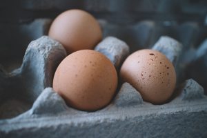 three brown eggs in a carton