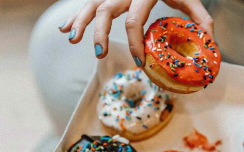 a hand reaching for donuts