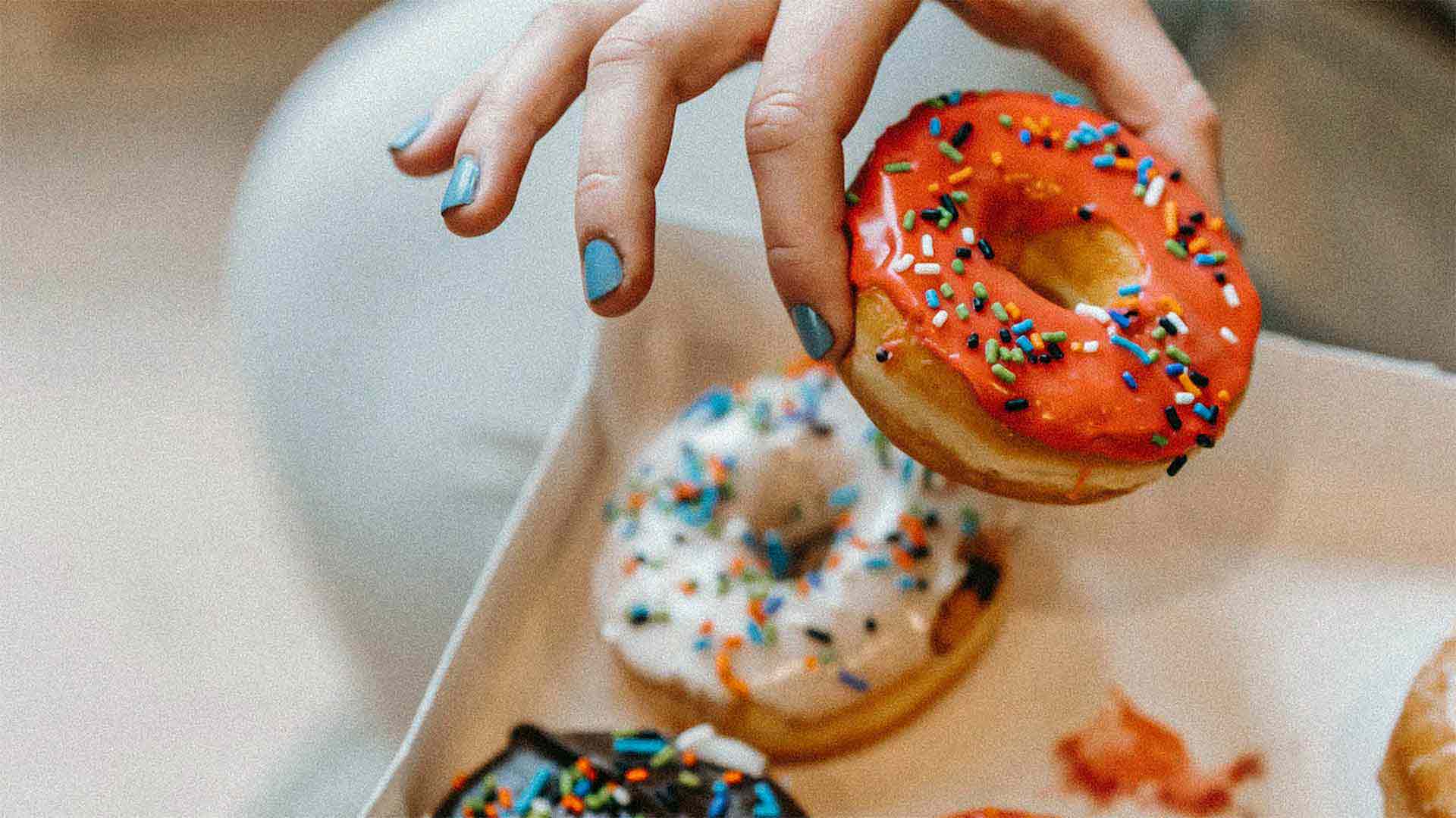 a hand reaching for donuts