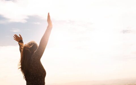 Woman raising her hands in sunlight symbolizing renewed energy and vitality supported by Spring Reset Supplements.
