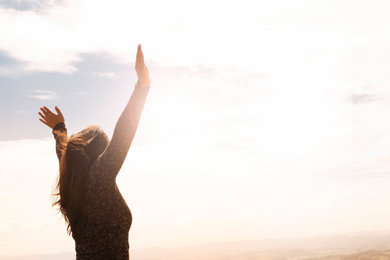 Woman raising her hands in sunlight symbolizing renewed energy and vitality supported by Spring Reset Supplements.