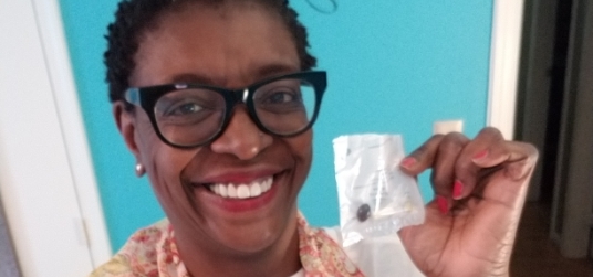 Woman smiling and holding Persona vitamin pack